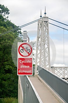 Ã¢â¬ÅNo cyclingÃ¢â¬Â sign with inscript Ã¢â¬ÅCyclists please dismountÃ¢â¬Â on the pedestrian bridge photo